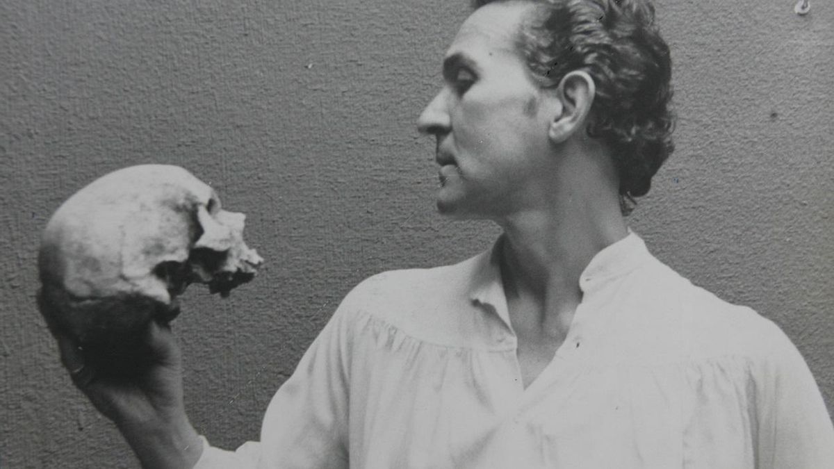 Imagen de archivo de un joven Antonio Gala que mira de frente a una calavera.