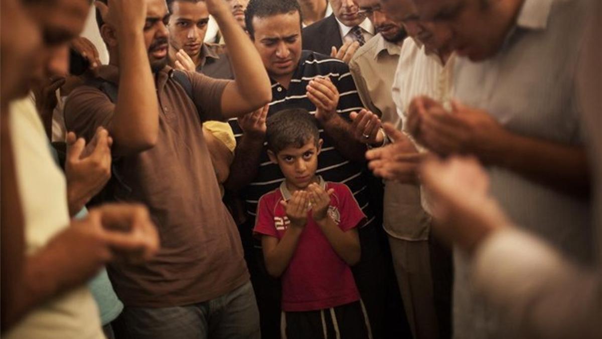 Un hijo de Ammar Badie, miembro de la Hermandad Musulmana muerto en los enfrentamientos de la plaza Ramsés, reza en el funeral, ayer