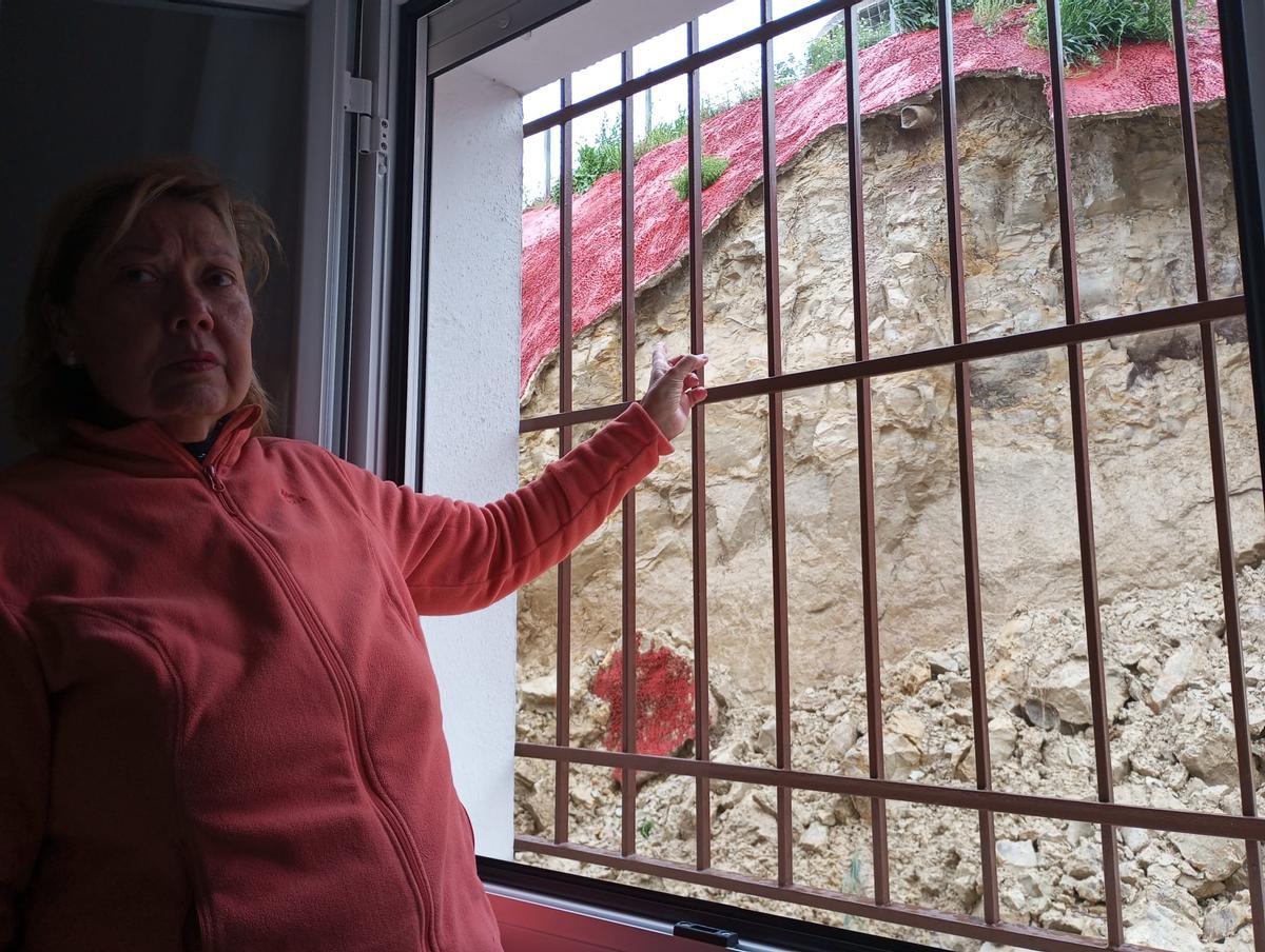 Una mujer muestra los desperfectos en una de las viviendas afectadas por el alud.