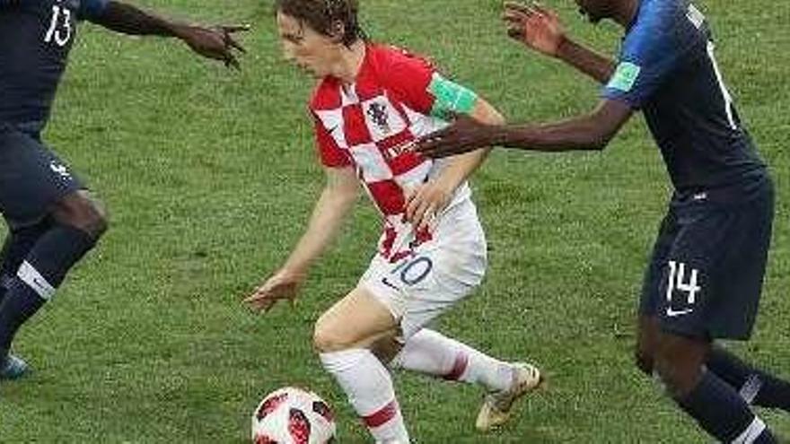 A la derecha, Modric controla el balón ante Kanté y Matuidí, ayer en Moscú. Debajo, Mbappé besa la Copa del Mundo y en el círculo Griezmann celebra su gol.