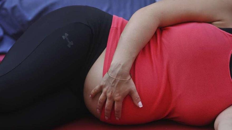 Una mujer en una clase de yoga para embarazadas.