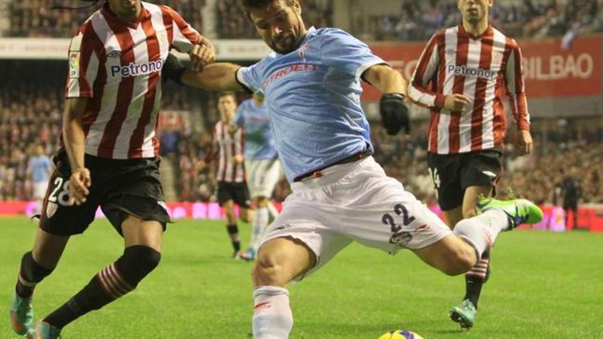 Perseguido por Susaeta, Quique de Lucas se dispone a golpear la pelota ante la oposición de Ramalho, ayer en San Mamés. // LOF