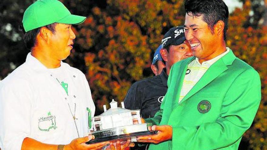 Matsuyama bromea con su ‘caddie’ mientras sostiene el trofeo de campeón del Masters. |  // AFP