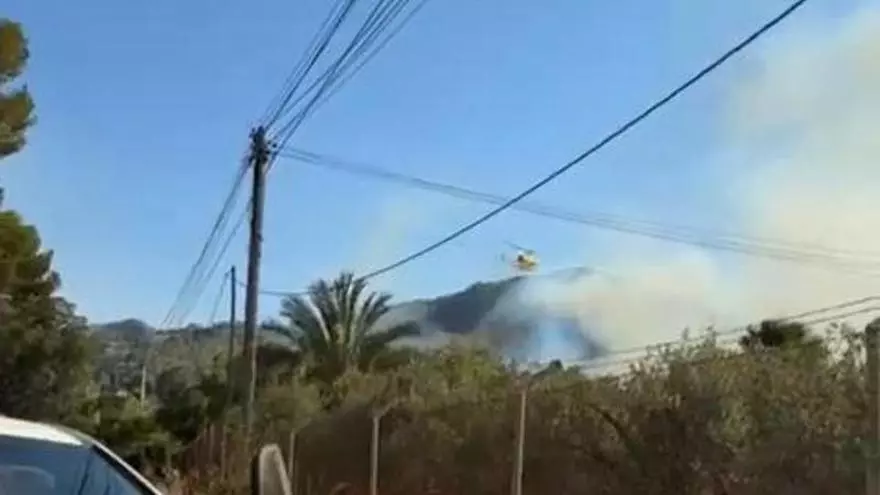 Un helicóptero echa agua sobre un incendio en Beniaján