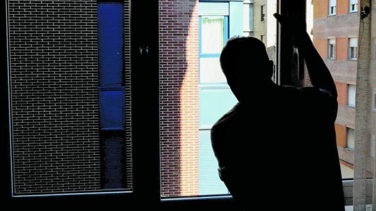 Francisco Javier mira a la calle desde la ventana de su casa.