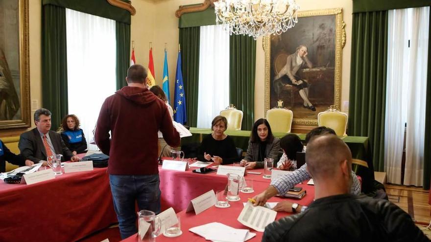 El dirigente vecinal Adrián Arias, de espaldas, entrega el informe sobre la contaminación en El Lauredal a la alcaldesa, Carmen Moriyón, al inicio de la reunión del Consejo Sectorial de Medio Ambiente de Gijón, ayer.