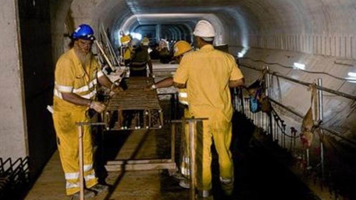 Unos operarios trabajan en la estructura interior del túnel de la L-9/L-10 en la estación de Collblanc, ayer.