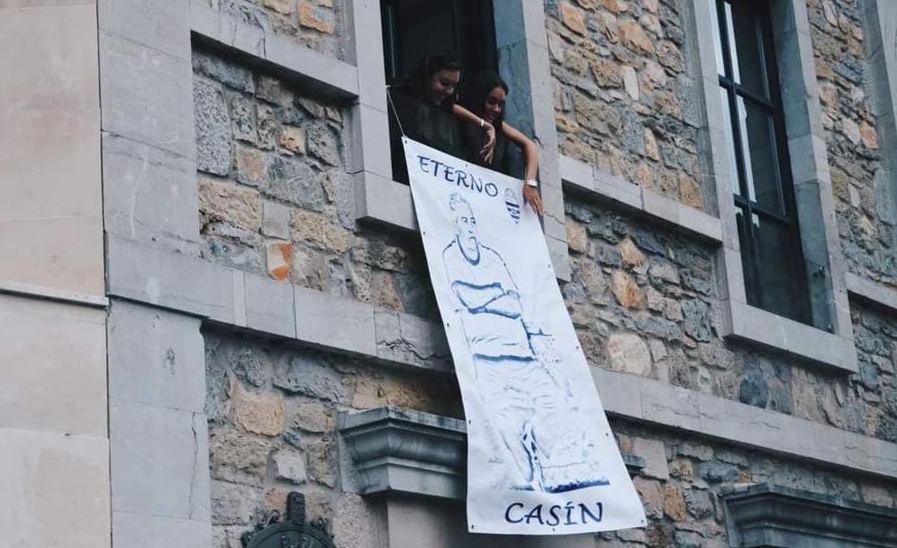 Varias vecinas cuelgan una pancarta en recuerdo de &quot;Casín&quot; en el balcón del Ayuntamiento para el pregón de las últimas fiestas patronales, el pasado agosto