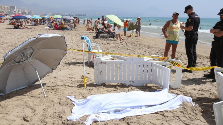 Dos agentes junto al cadáver tapado de la bañista,