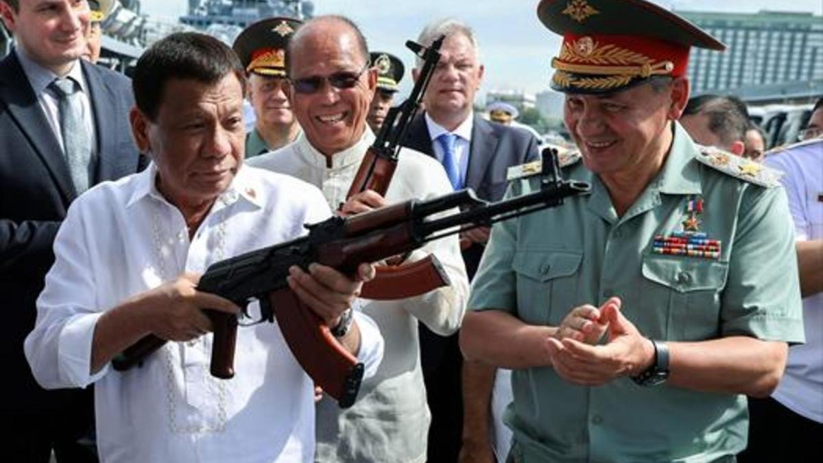 Duterte prueba un kalashnikov con el ministro ruso Sergei Shoigu.