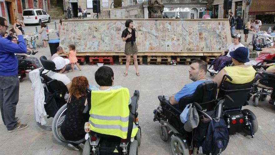 Miembros de APAMP delante del mural que han creado con 200 kilos de barro. // Alba Villar