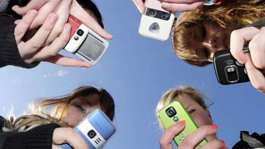 Un grupo de jóvenes con sus teléfonos móviles.