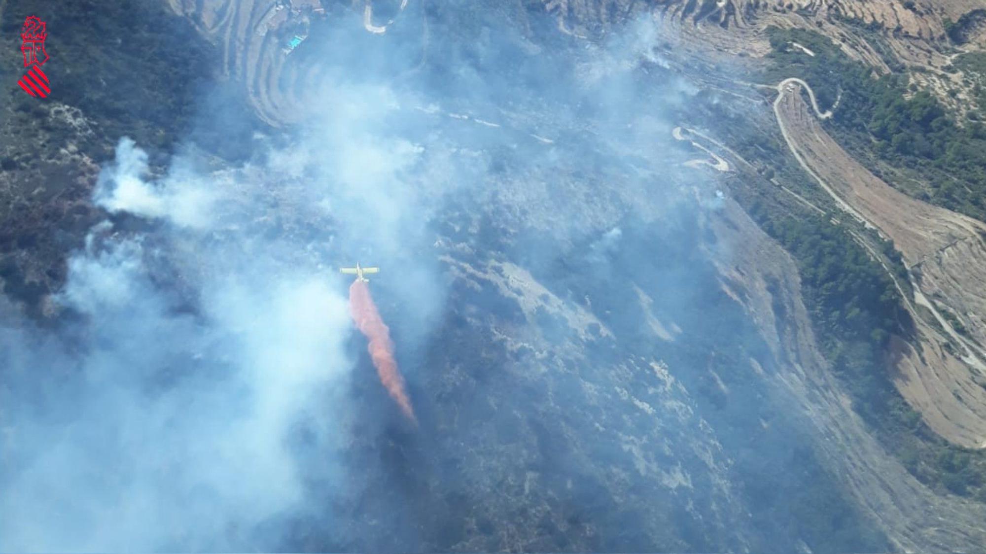 Efectivos aéreos y medios terrestres tratan de sofocar un incendio en la Serra d'en Galceran