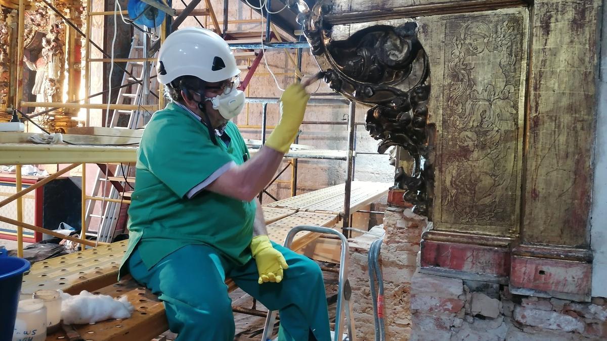 Un alumno del centro trabaja en la recuperación de la policromía dorada de un retablo