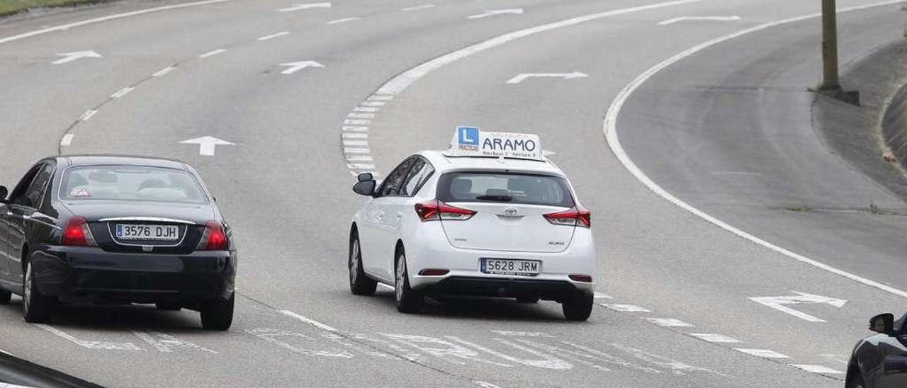 Un coche de autoescuela, ayer, circulando por Oviedo.