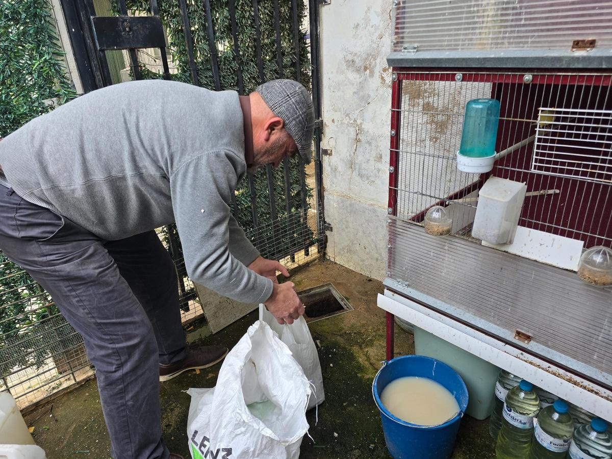 Francisco Delgado tapona uno de los sumideros de su patio para evitar que el agua entre en su domicilio en las casas aisladas de Gévora.