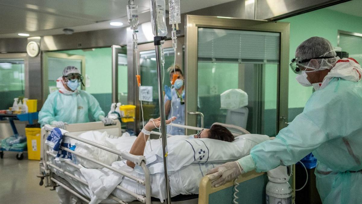Dos sanitarios trasladan a un paciente a una unidad covid en el Hospital Universitario de Canarias. | |
