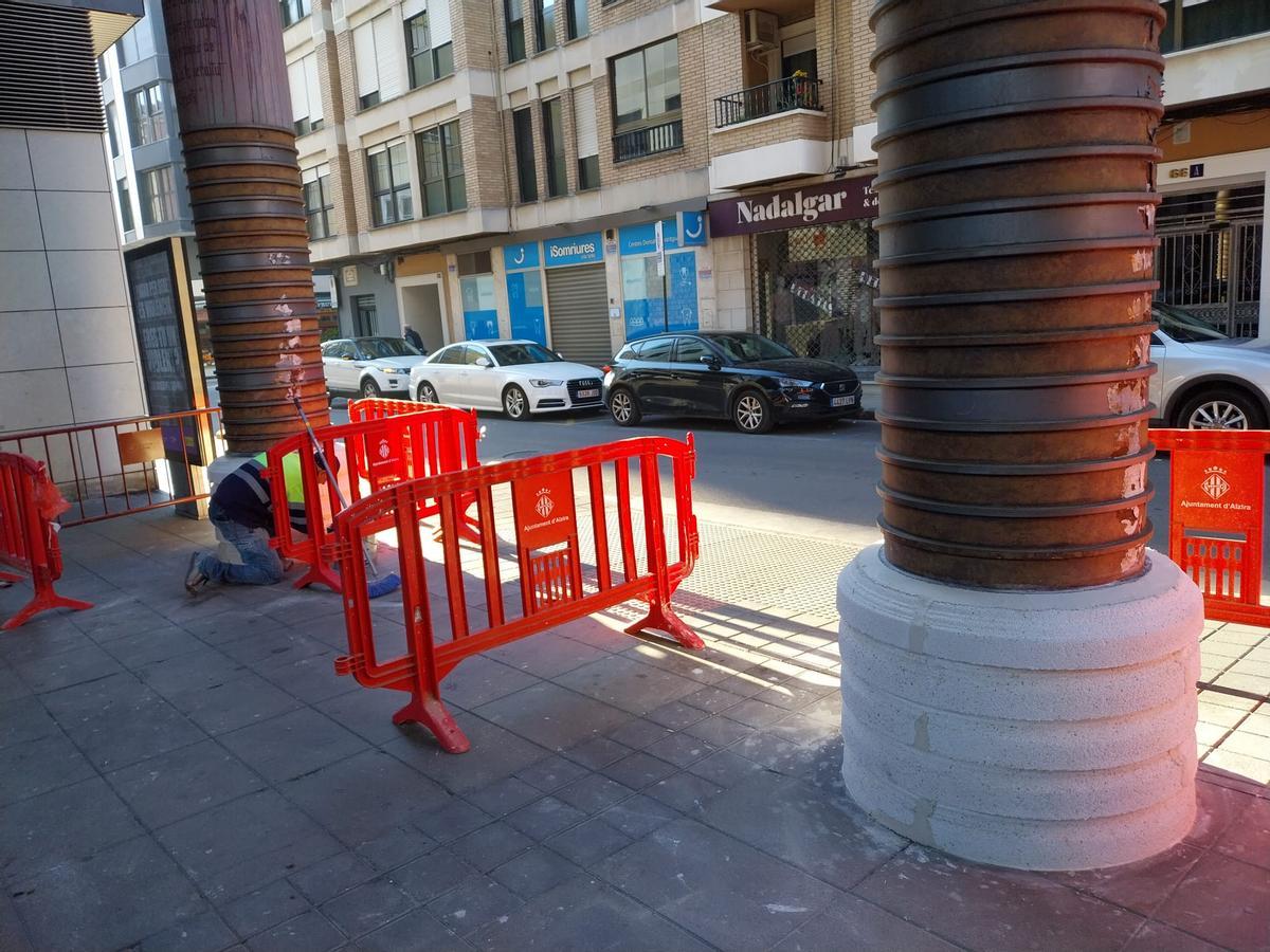 Un operario trabaja en la instalación un nuevo revestimiento para las columnas.