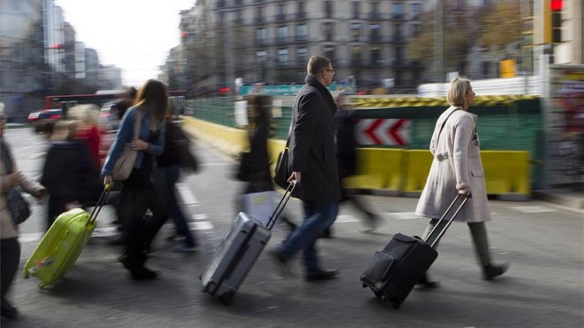 Turistas recién llegados acarrean maletas en la confluencia de Aragó con paseo de Gràcia, ayer