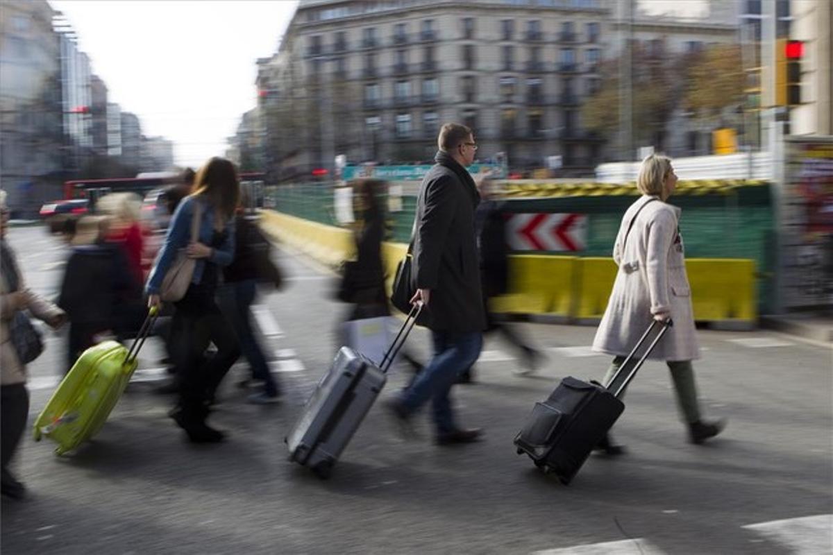 Turistes que acaben d’arribar carreguen maletes a la confluència d’Aragó amb el passeig de Gràcia, ahir. Turistes que acaben d’arribar carreguen maletes a la confluència d’Aragó amb el passeig de Gràcia, ahir.