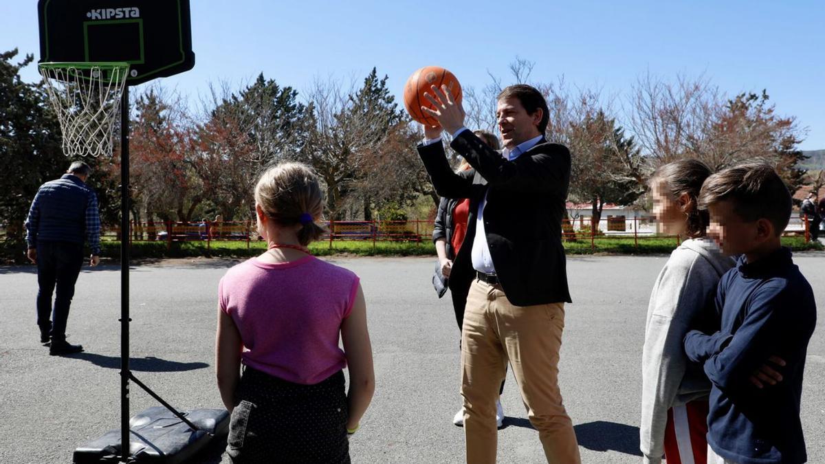 El presidente Fernández Mañueco juega con unos niños al baloncesto durante su visita al colegio de La Inmaculada de Salamanca ayer. | D. Arranz. - Ical