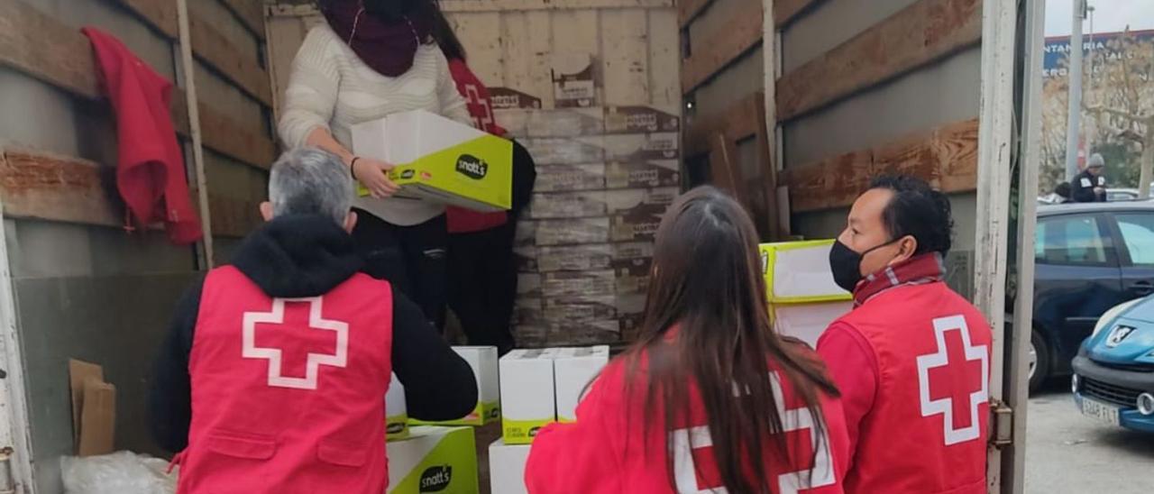 Voluntarios descargando comida para los más necesitados. | LEVANTE-EMV