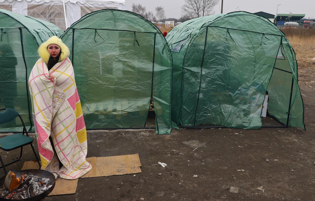 Una mujer que huye de la invasión rusa en Ucrania entra en calor en un centro de acogida para refugiados en Medyka, en la frontera polaca.