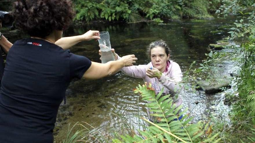 Voluntarios de Adega, recogiendo muestras de agua del río Liñares, en A Estrada.