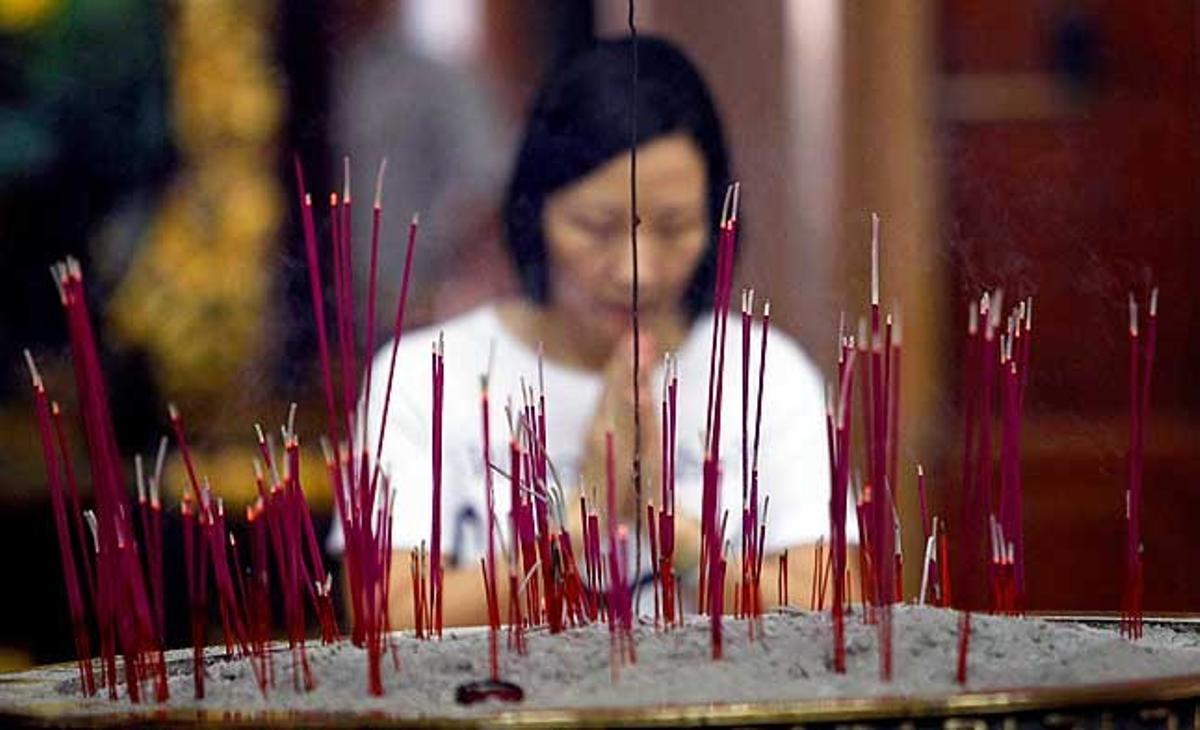 Una dona resa dins un temple xinès a Manila (Filipines).