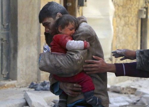 A boy holds his baby sister saved from under rubble, who survived what activists say was an airstrike by forces loyal to Syrian President Bashar al-Assad in Masaken Hanano in Aleppo