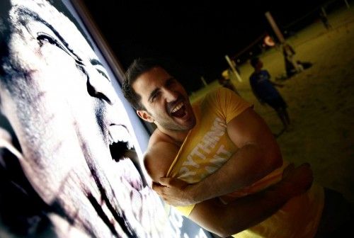A man makes a funny face as he poses for a photograph next to an advertising placard showing Uruguay's striker Luis Suarez flashing his teeth at Copacabana beach in Rio de Janeiro