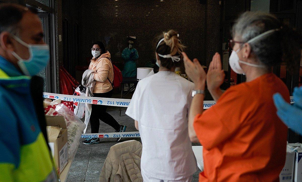 El personal sanitario del hospital de campaña de Ifema aplaude a una joven que acaba de recibir el alta, el martes.