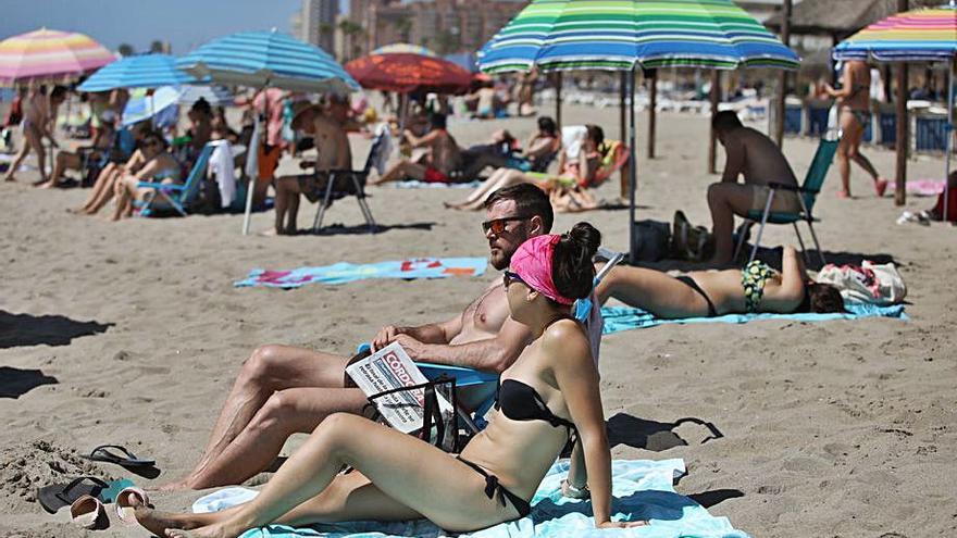 Una pareja toma el sol en una playa malagueña.