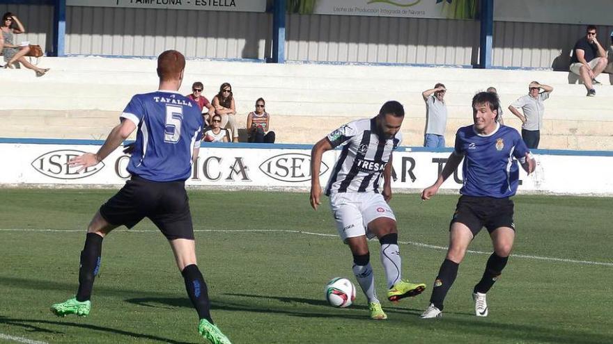 Pedro Beda toca el balón entre dos jugadores del Peña Sport.