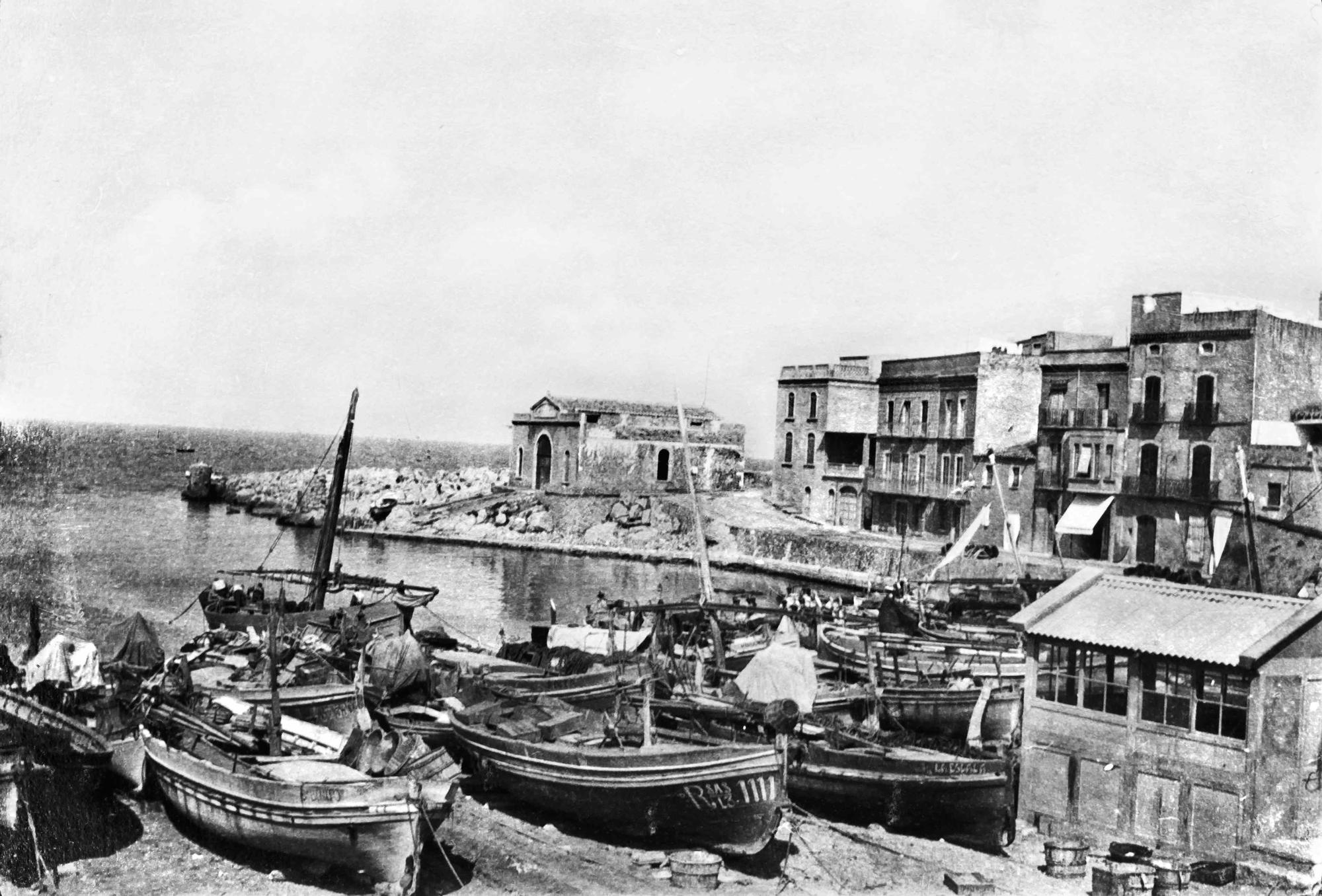 La platja de l'antic port de l'Escala amb l'antiga caseta de la màquina de treure les barques.