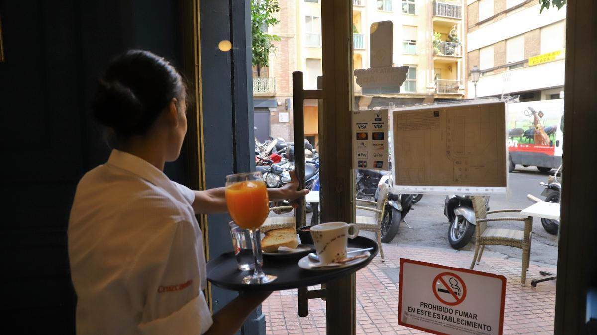 Una camarera de un bar de Córdoba sale con una bandeja.