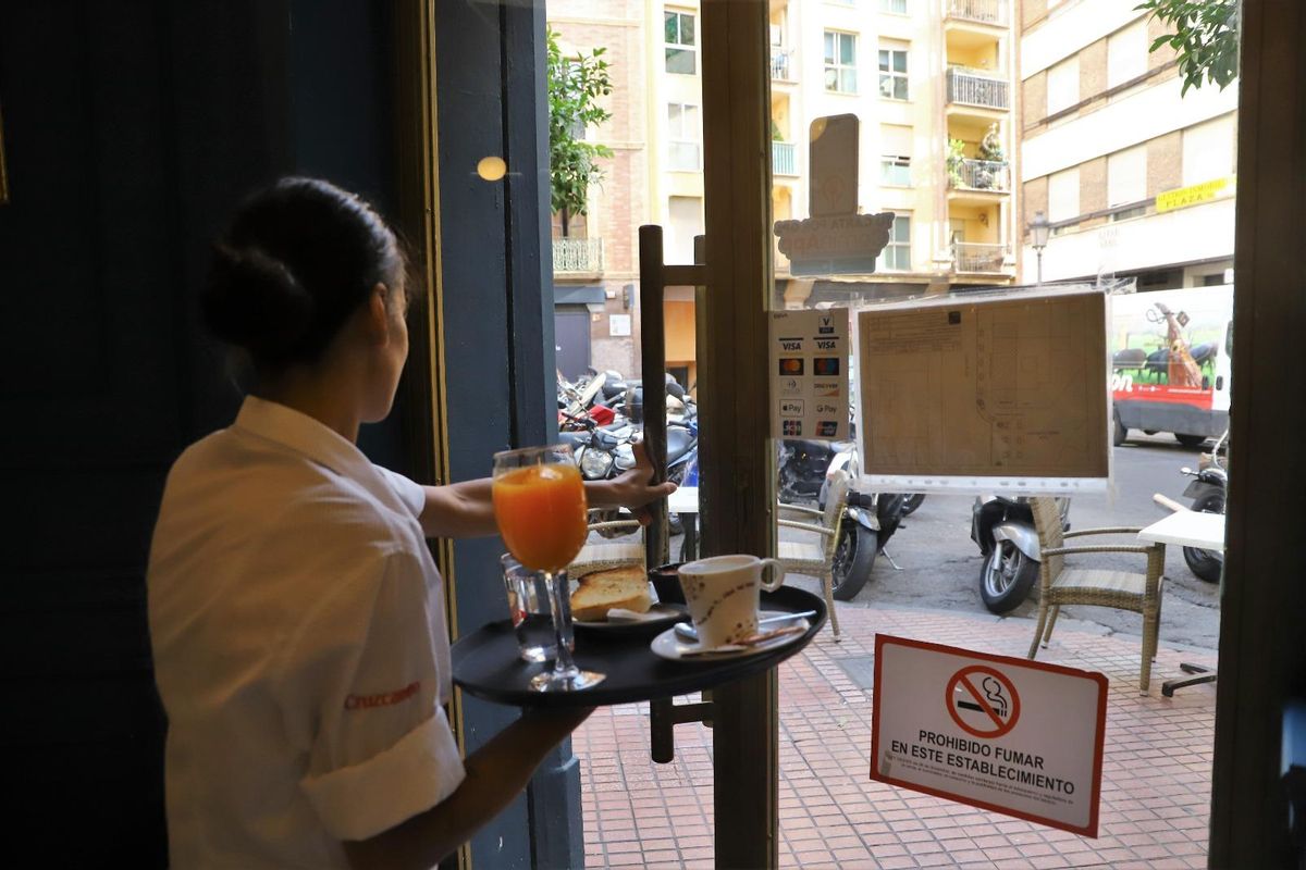 Una camarera de un bar de Córdoba sale con una bandeja.