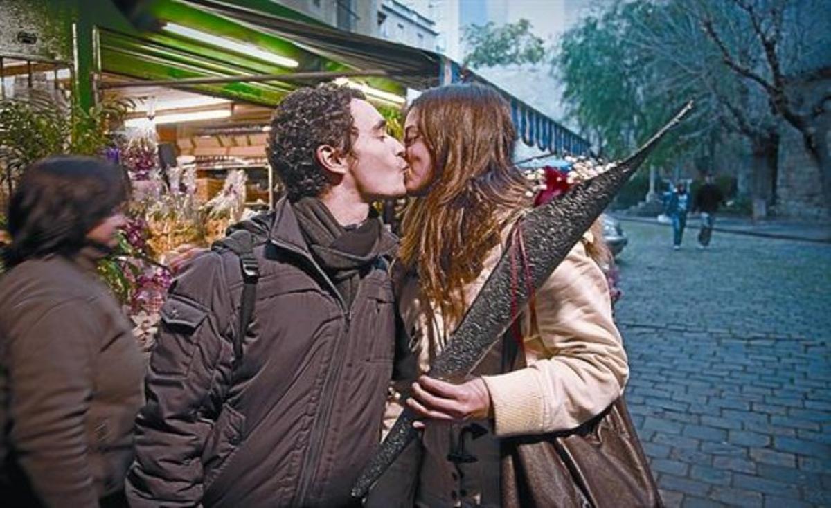 Una parella d’enamorats, ahir, davant una parada de flors del carrer de Santa Anna. Una parella d’enamorats, ahir, davant una parada de flors del carrer de Santa Anna.