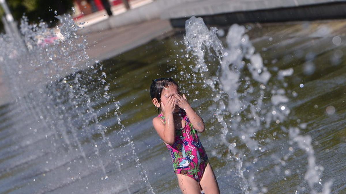Una niña se refresca en una de las fuentes de Córdoba.