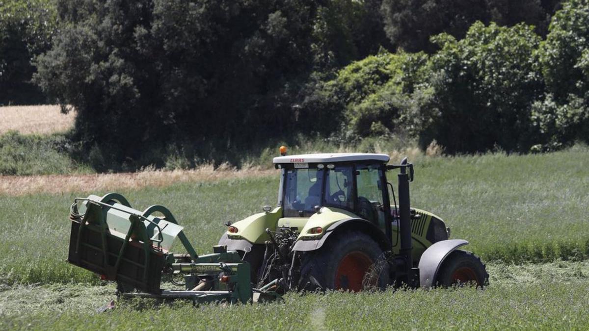 Imatge d’arxiu d’un pagès treballant amb un tractor