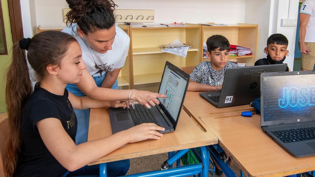 Una monitora guía a una joven usuaria por un programa informático.