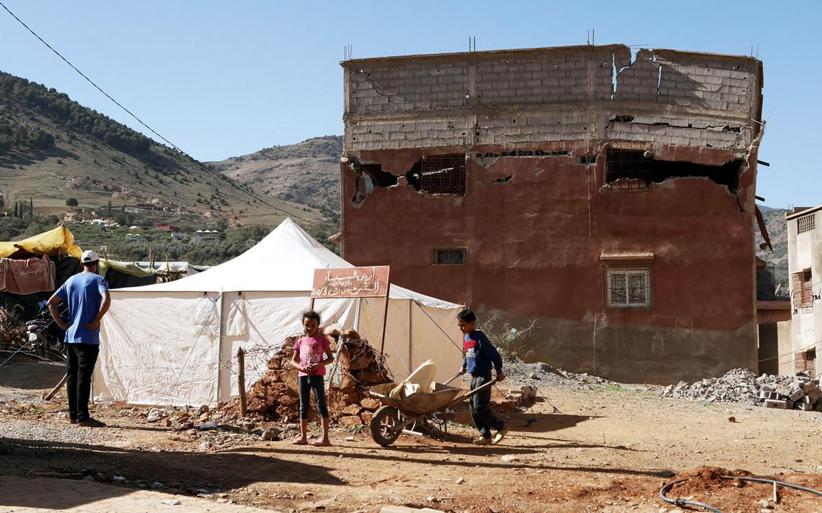 Hicham y sus hijos montan una nueva tienda de campaña en frente de la que fue su vivienda, ahora derrumbada.