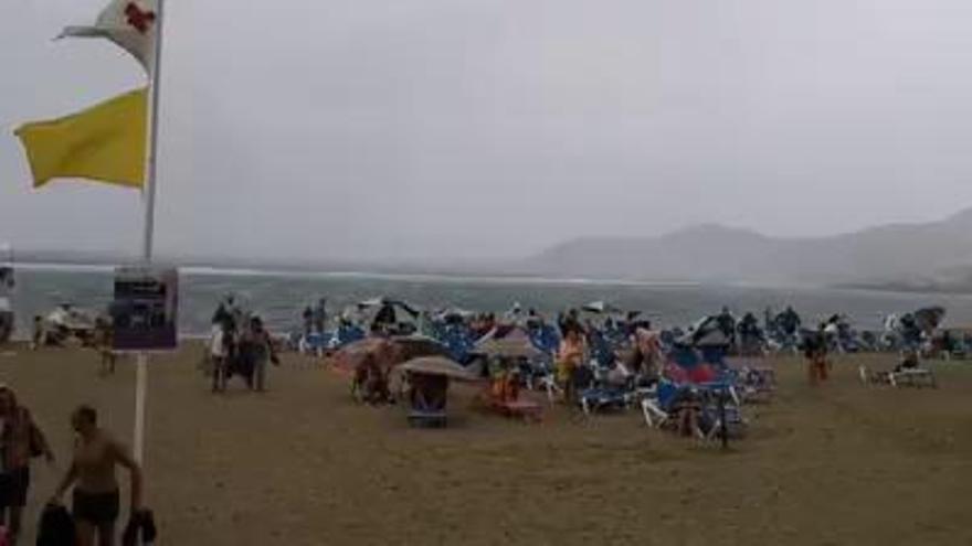 La lluvia sorprende a los bañistas en Las Canteras