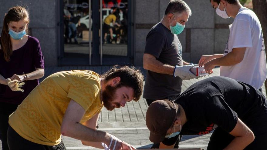 Voluntarios de la Fundació Arrels se disponen a repartir comida.