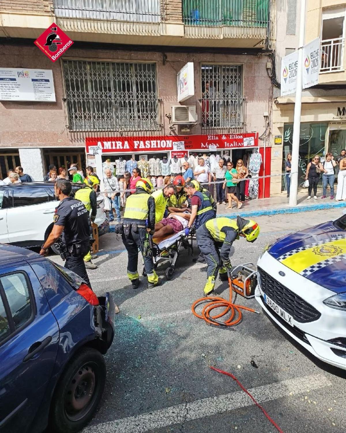 Bomberos y personal sanitario sitúan al herido sobre una camilla para trasladarlo a un centro hospitalario de Elche