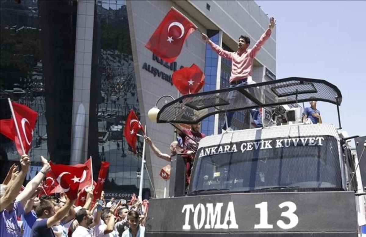 Partidarios de Erdogan celebran el fracaso del golpe, sobre un vehiculo policial en Ankara