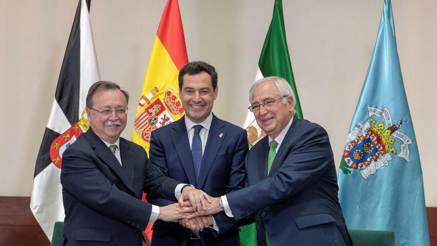 El presidente de la Junta de Andalucía, Juanma Moreno (c), y los presidentes de las ciudades autónomas de Ceuta, Juan Jesús Vivas (i), y Melilla, Juan José Imbroda (d), juntan sus manos tras firmar hoy en el Palacio de San Telmo.