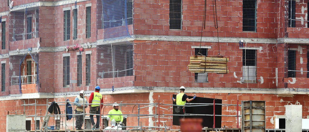 Obreros en un edificio en construcción en València. | J.M. LÓPEZ