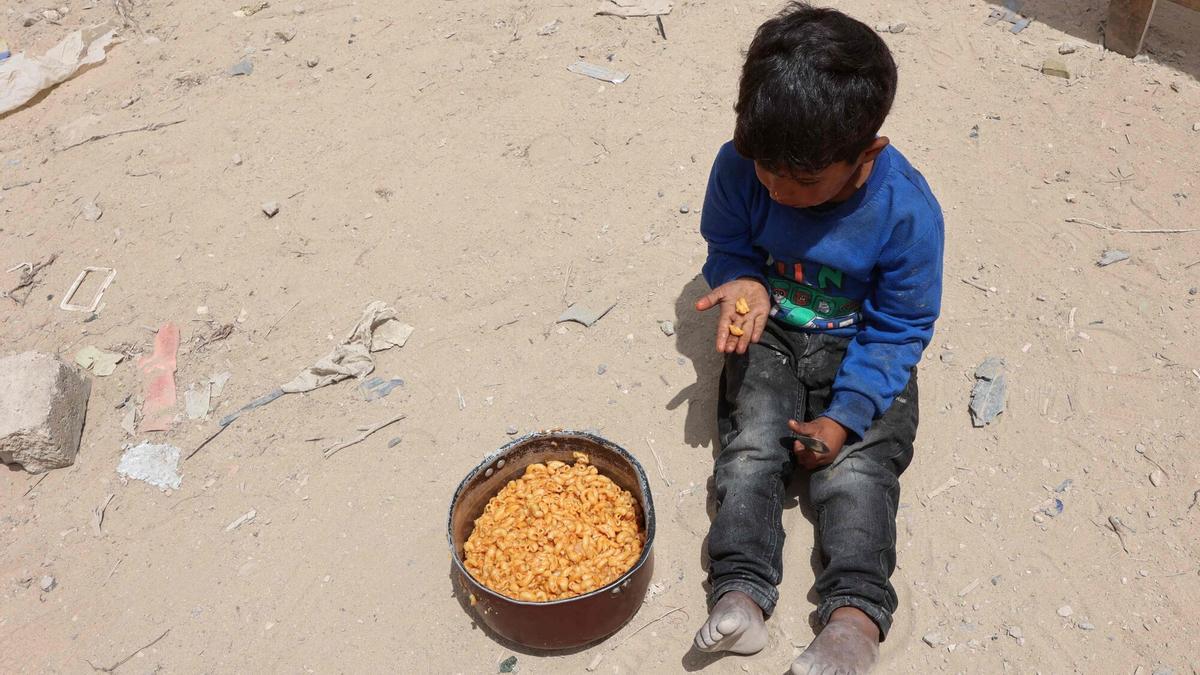 Un niño palestino junto a una ración de comida en Gaza, este mayo