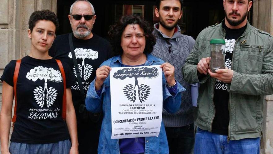 Representantes de la Plataforma contra la Contaminación posan, ayer, con el cartel de la movilización y un tarro de partículas recogidas en Veriña, con Adrián Arias a la derecha y Gala Fernández a la izquierda.